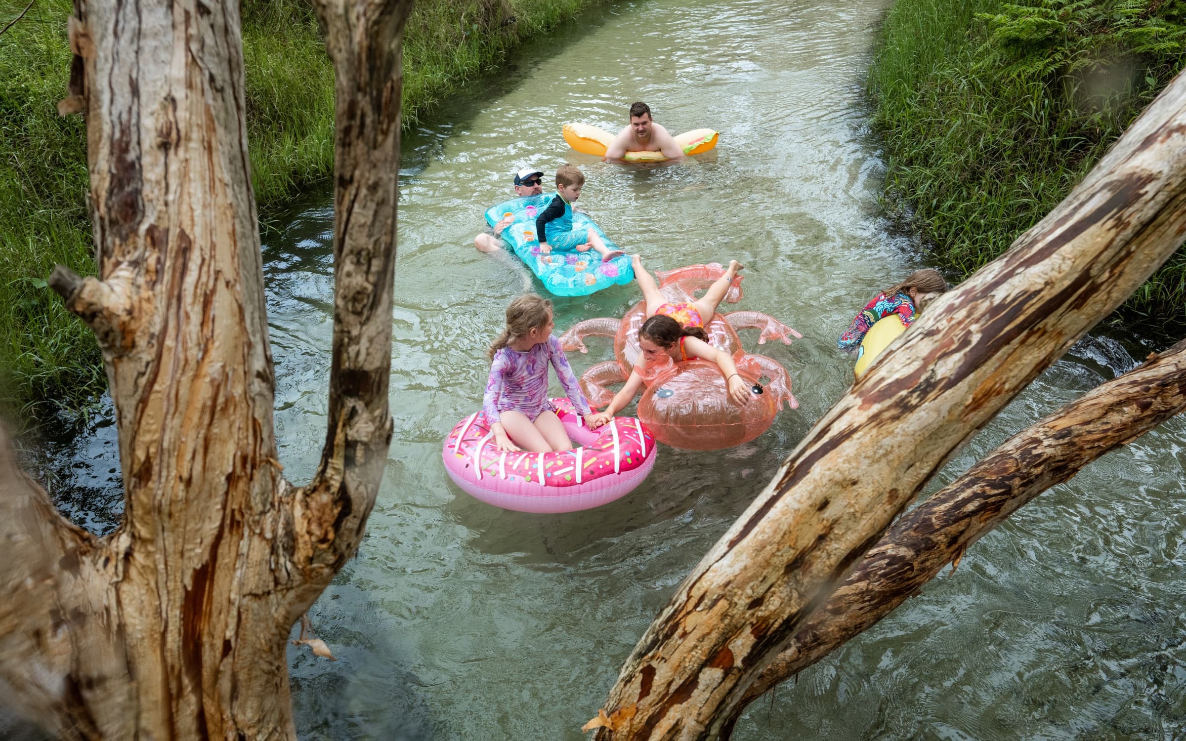 Families floating down Eli Creek on inflatables