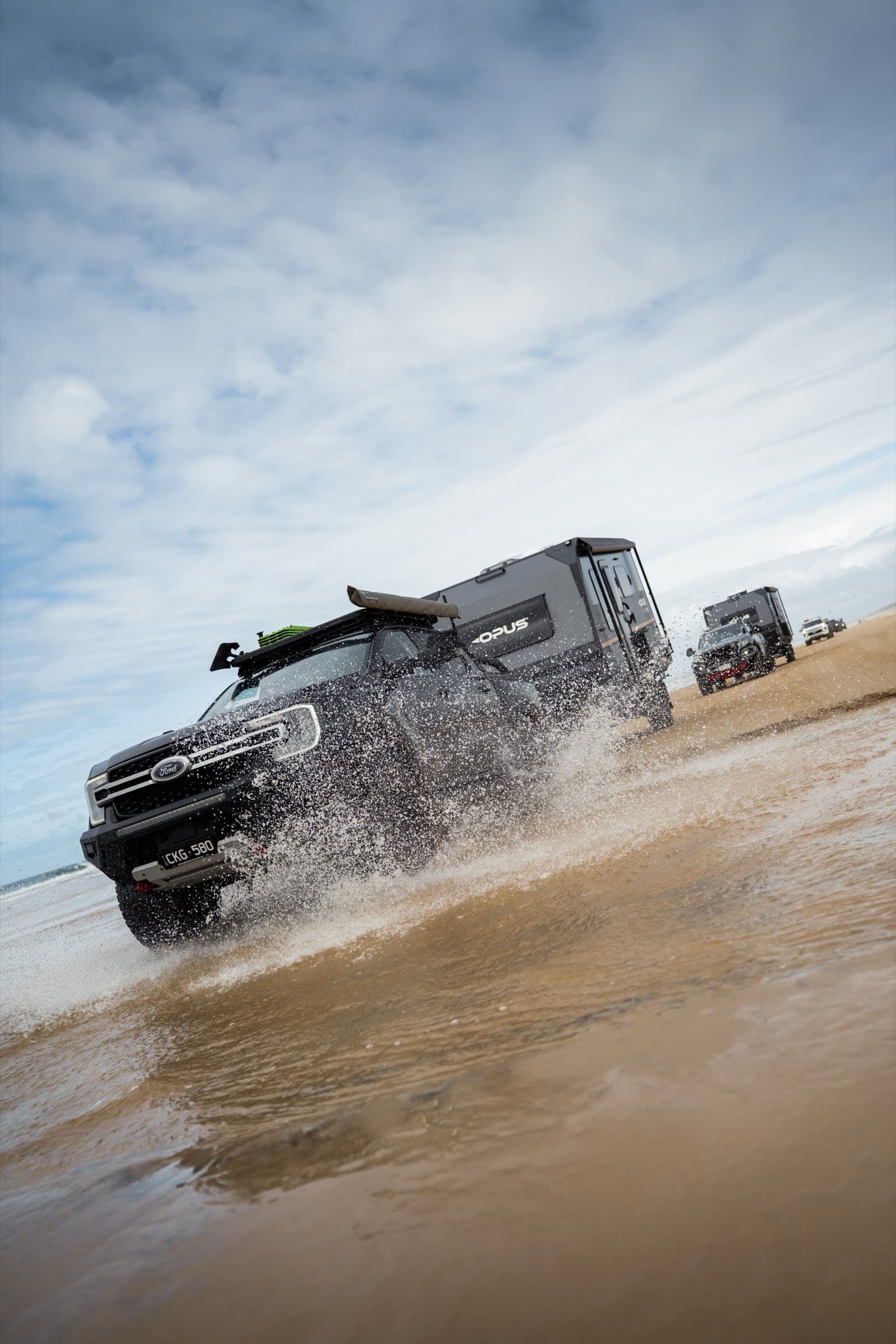OPUS hybrid crossing a shallow creek on the beach
