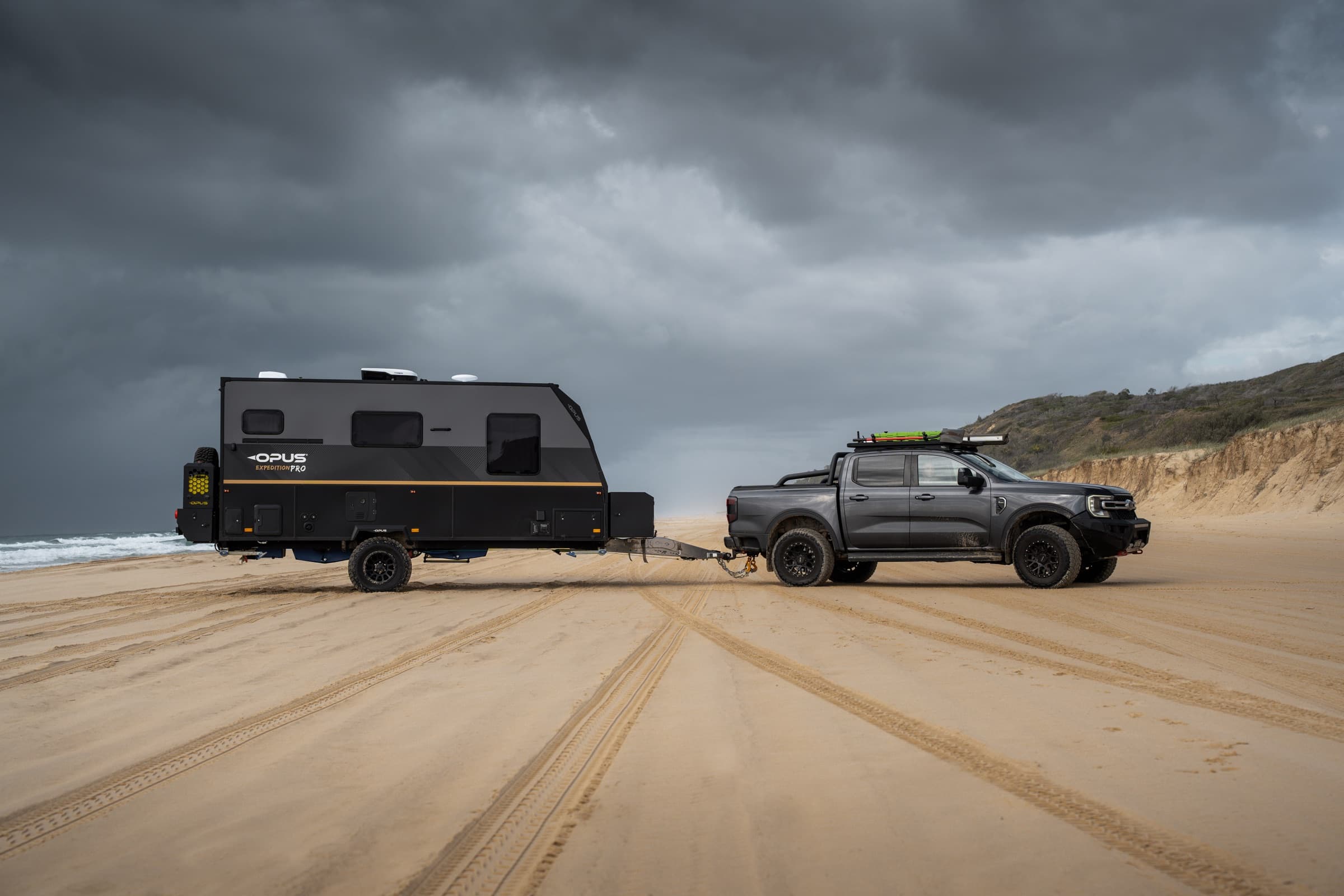 OPUS hybrid and tow vehicle under a storm sky