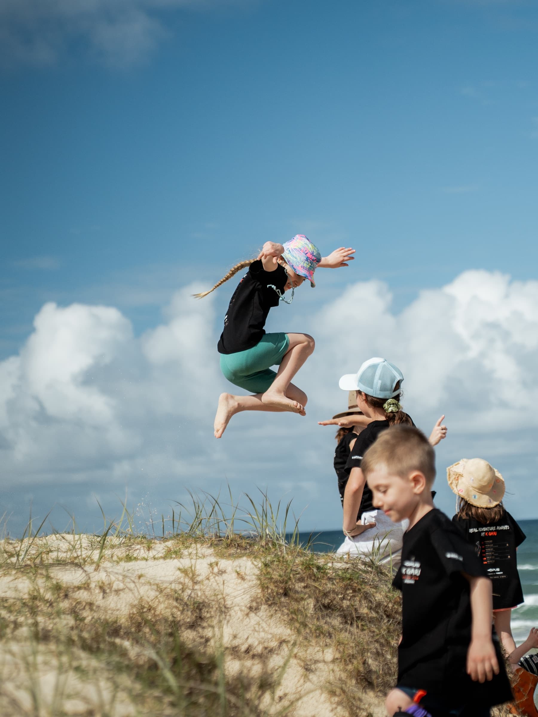 Kid jumping off a sand dune