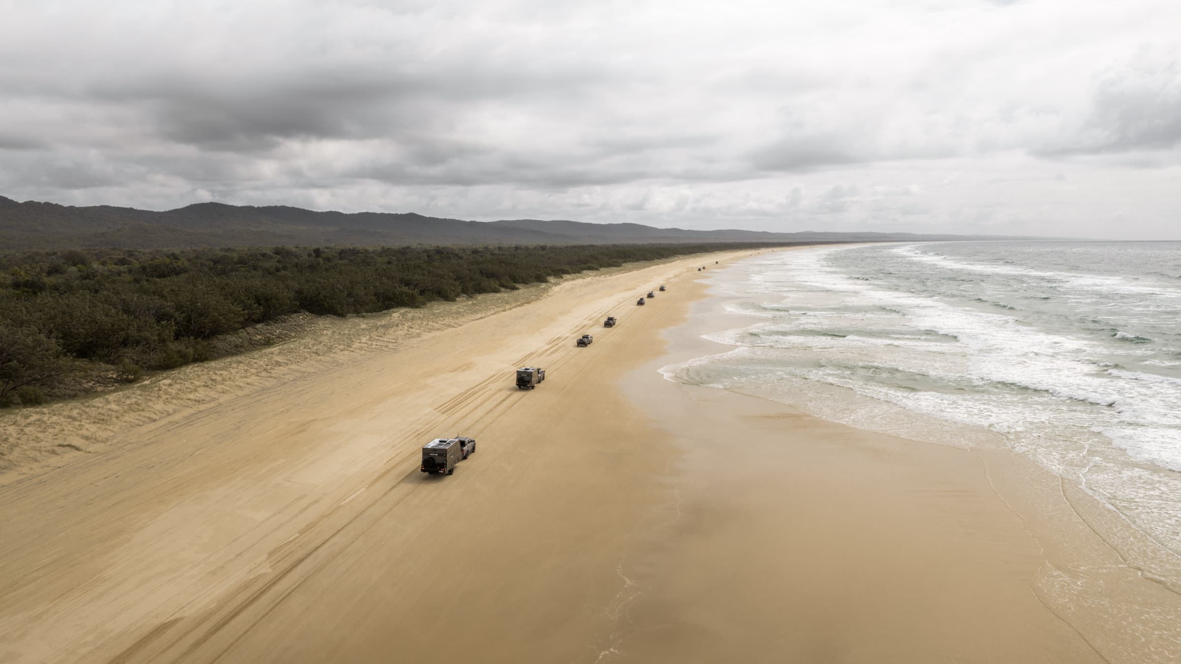 Aerial of the convoy on the beach with storm clouds
