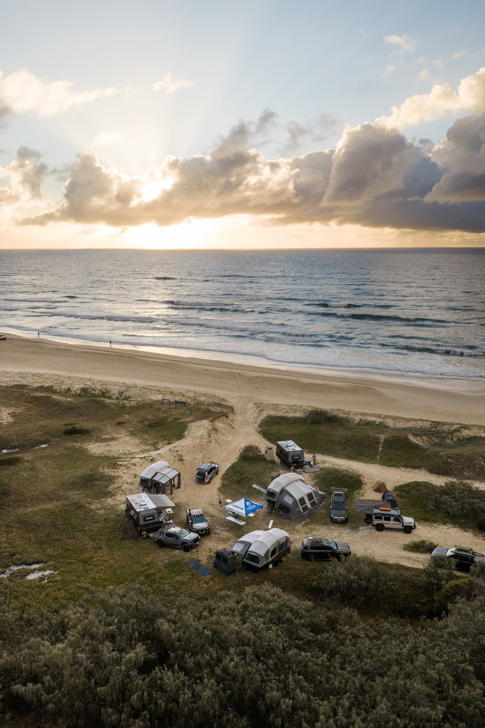 Aerial of the OPUS camp behind the dunes at sunrise
