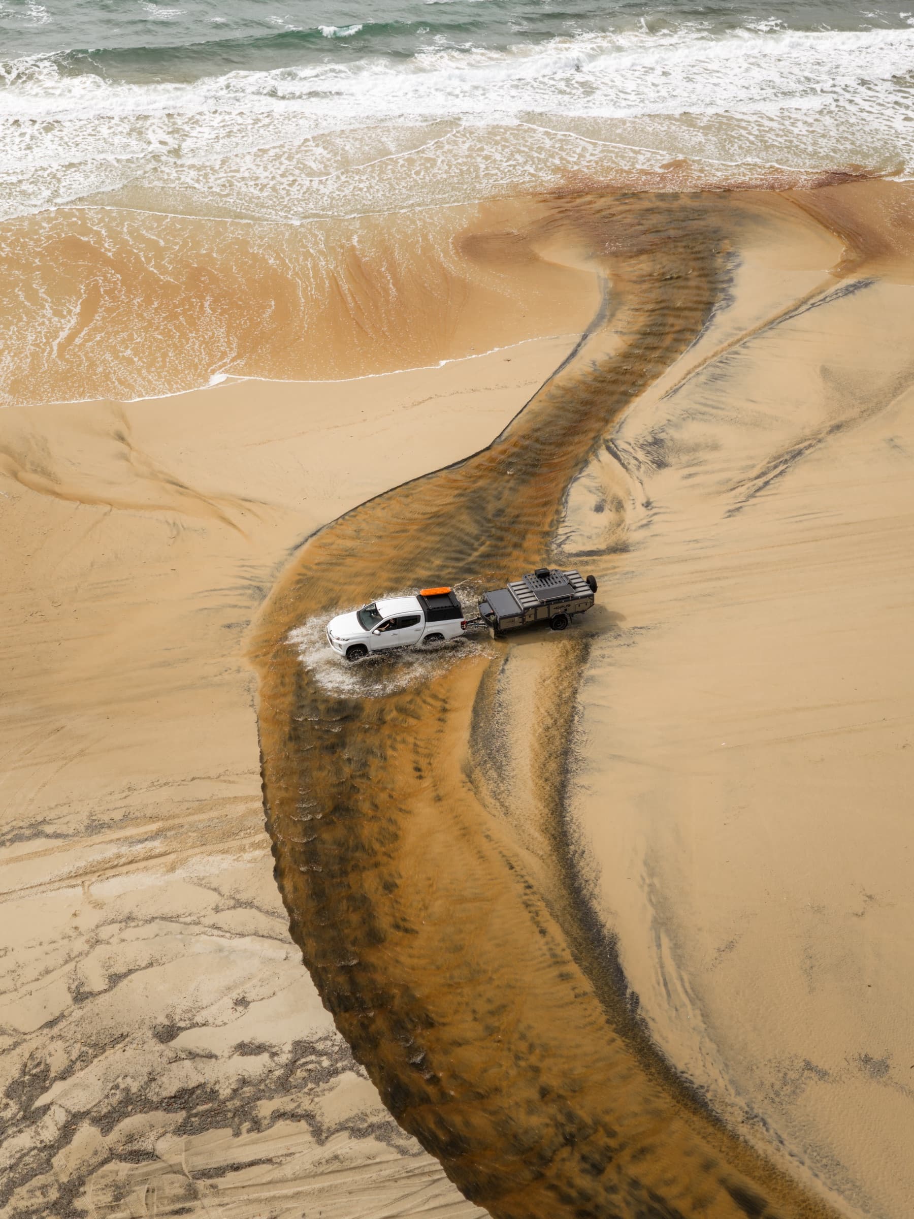 Aerial of an OPUS rig crossing a tidal creek on K'Gari