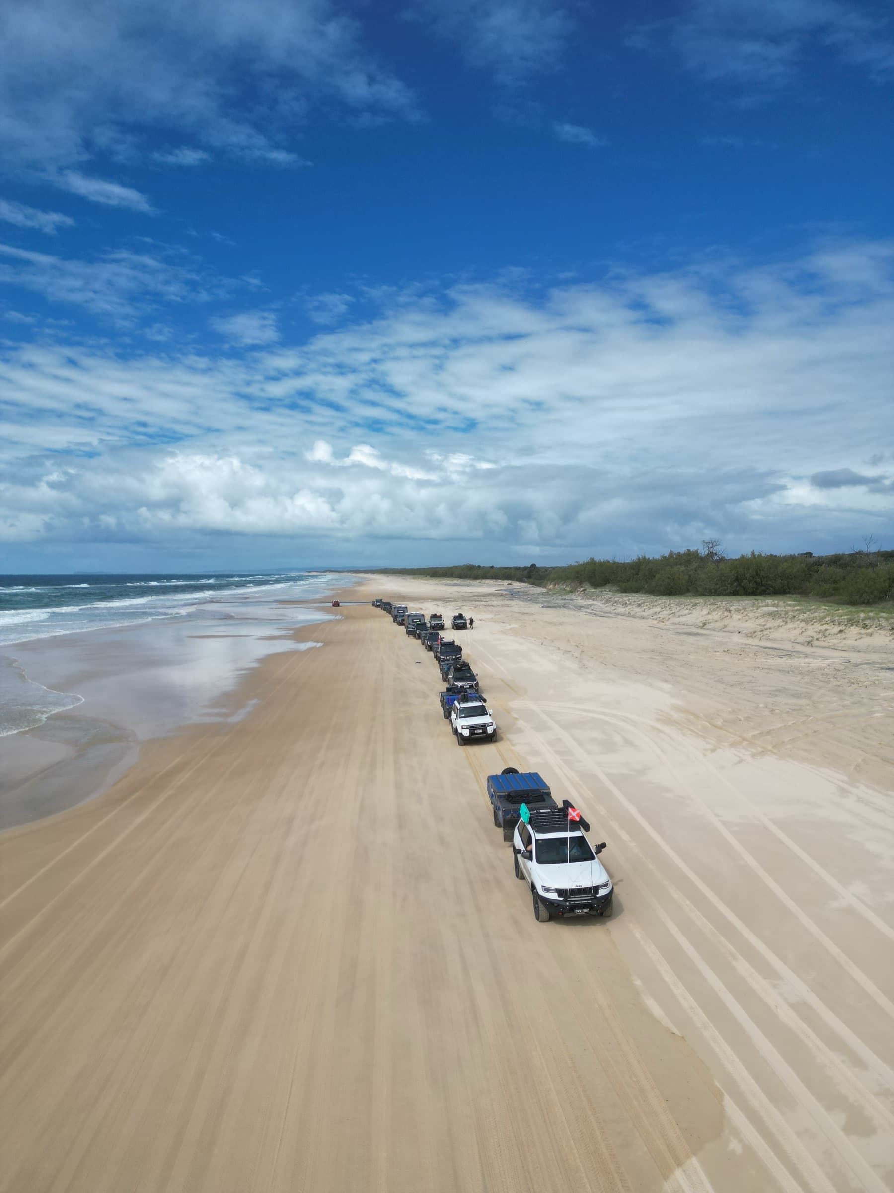 A convoy of OPUS campers strung out along the beach on an Adventure Run